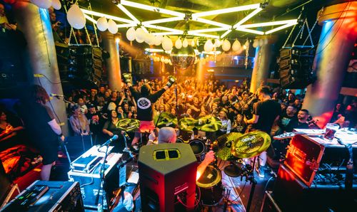 Free Exciting live performance in a packed nightclub with vibrant lighting. Stock Photo