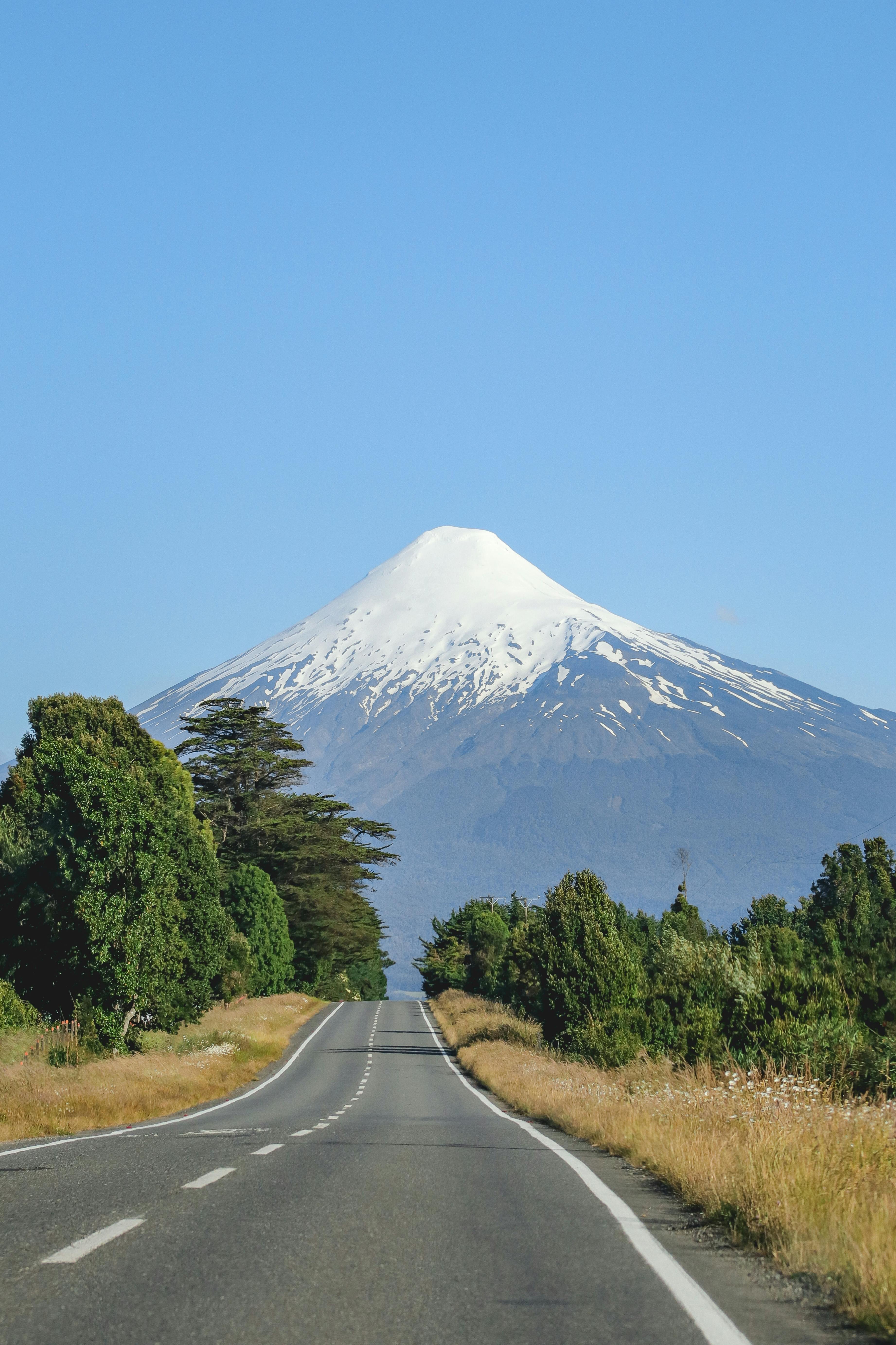 Serene view of a highway leading towards the majestic snow-capped Osorno Volcano in Los Lagos, Chile.