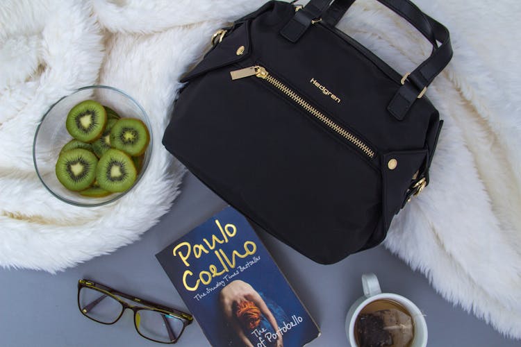 Healthy Kiwi Bowl Placed On Fur Blanket With Bag Book And Eyeglasses