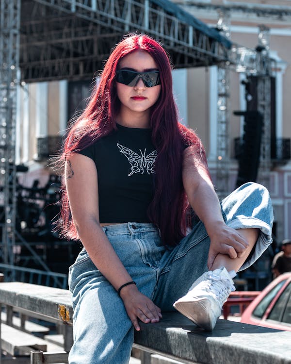 Young Woman in Casual Clothing Sitting Against the Scene Free