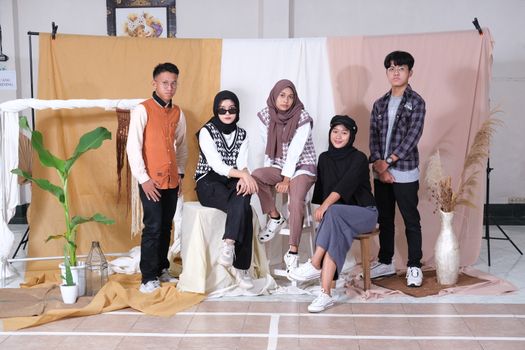 A group of stylish teenagers posing in a studio with modern decor and casual attire. - Fotografer Sidoarjo