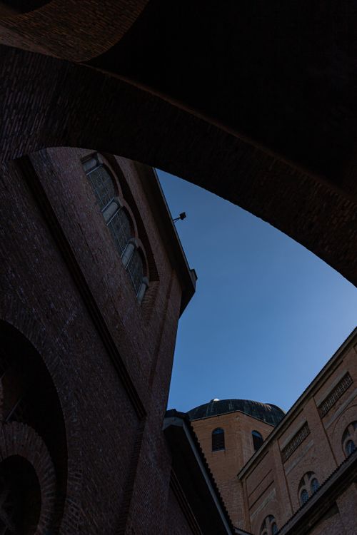 Free Dramatic low angle view of classic brick buildings with domes against a clear blue sky. Stock Photo