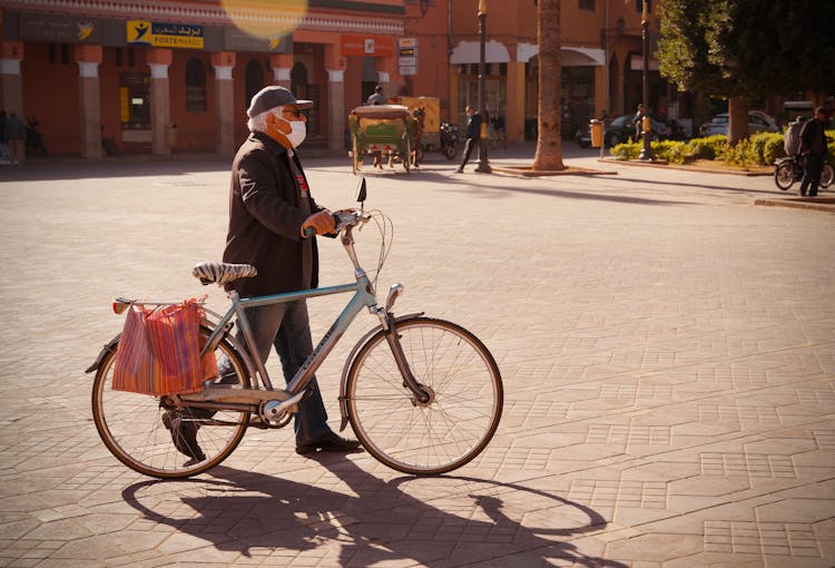 Man Leading Biycle In Town