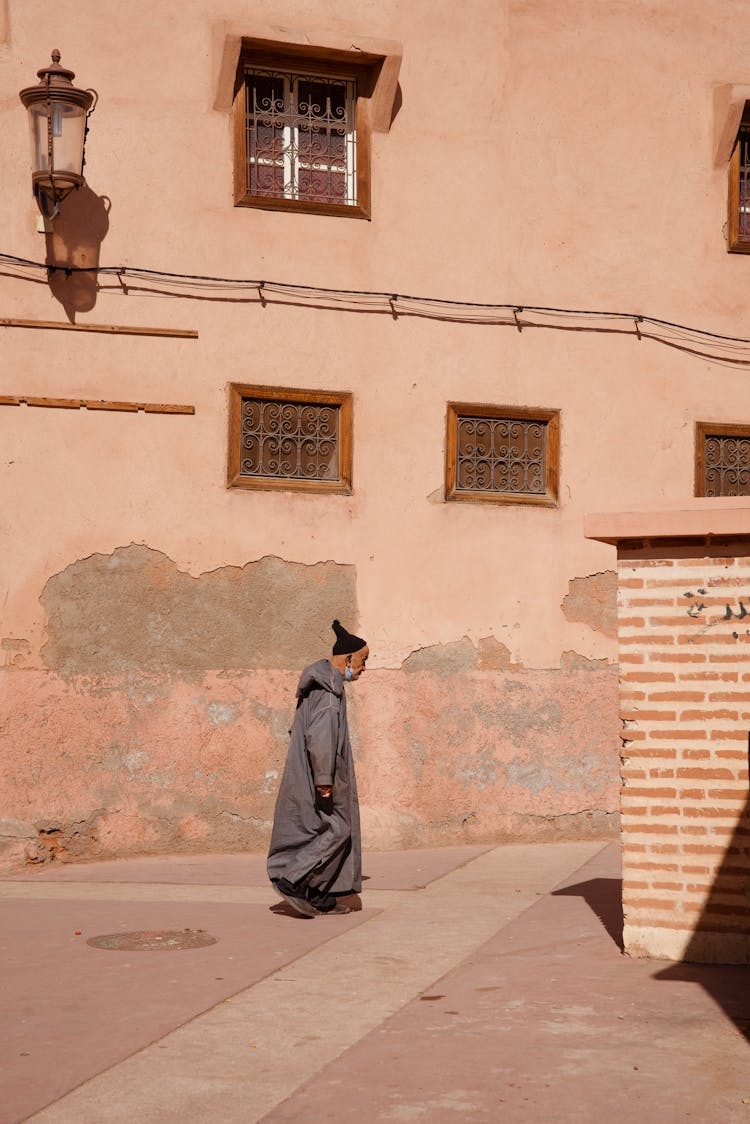 Man Walking On Sunlit Street