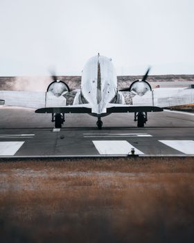 A twin-engine airplane prepares for takeoff on a runway, showcasing aviation technology.