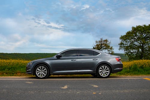 Skoda Superb on the Road with a Countryside Landscape in the Background 