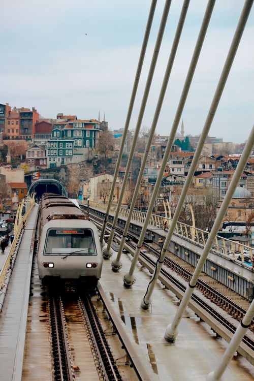 Free A metro train crosses the Halic Bridge with a view of Istanbul's historic cityscape. Stock Photo