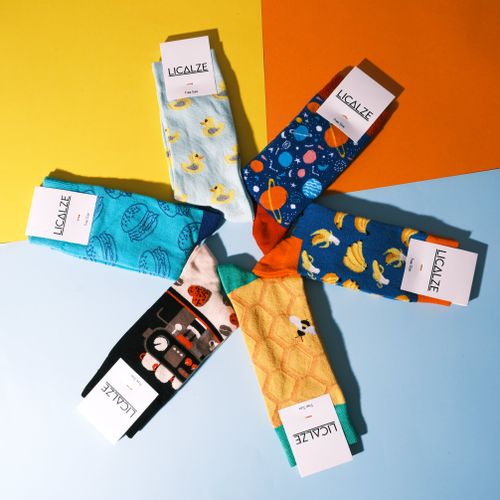 Free A vibrant collection of patterned socks displayed on a geometric colorful backdrop. Stock Photo