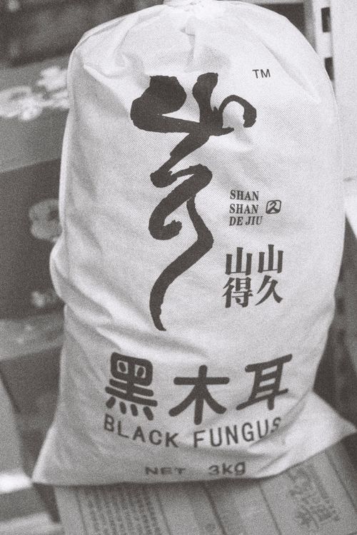 Free Retro-style close-up of a sack marked 'Black Fungus' with non-Western script, Lisbon location. Stock Photo
