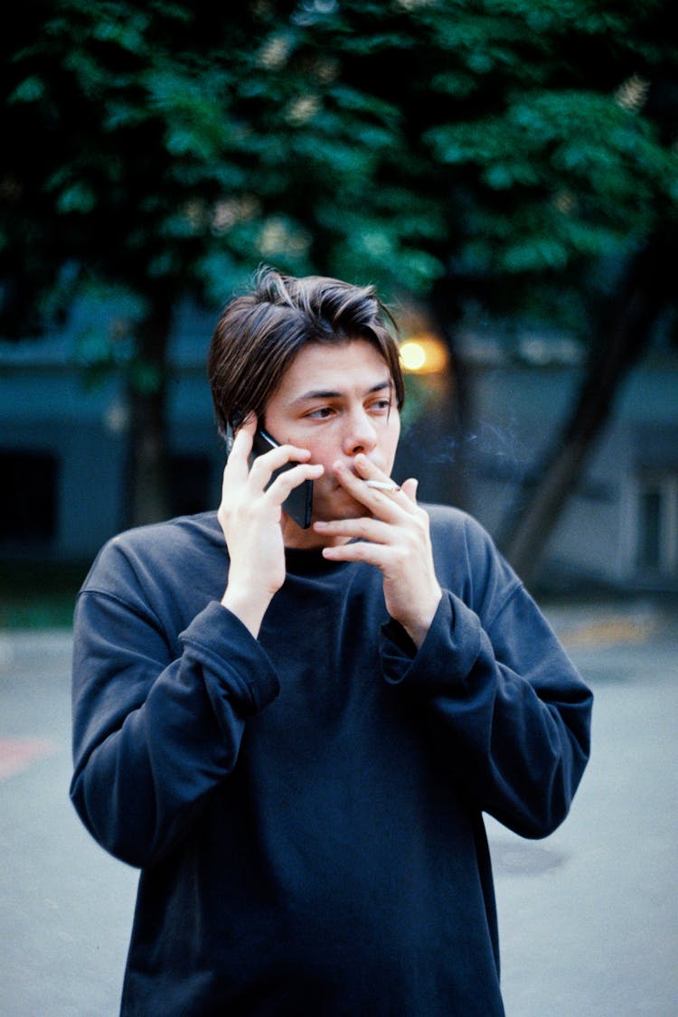 Man Talking On The Phone And Smoking A Cigarette 