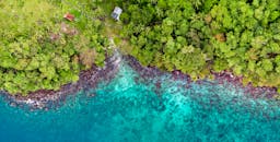 从空中俯瞰印度尼西亚苏卡卡亚，其充满活力的海岸线、郁郁葱葱的绿植与碧蓝海水构成了一幅令人惊叹的画面