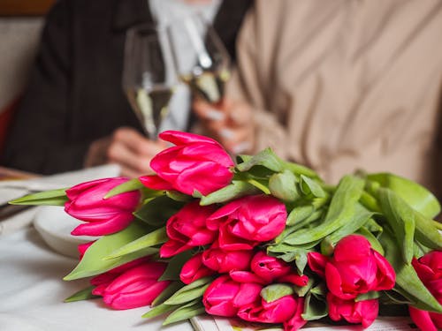 Red Tulips with Green Leaves on the Table