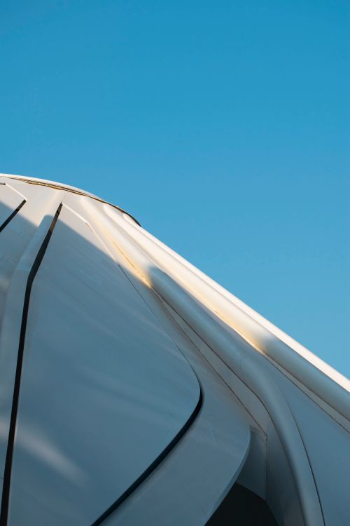 Free Close-up of a Dubai building's facade with modern design elements against a blue sky. Stock Photo