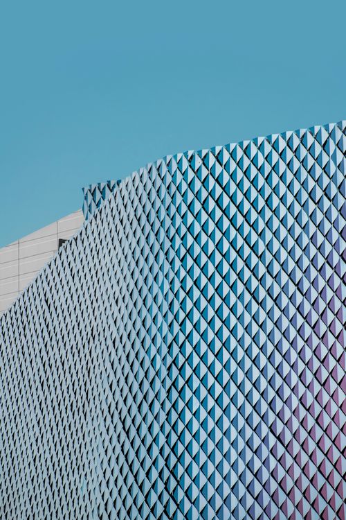 Free Contemporary building facade in Dubai, showcasing geometric design against a clear sky. Stock Photo