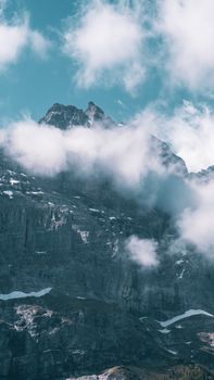 Majestic mountain peaks shrouded in mist and clouds, capturing a serene and dramatic landscape.