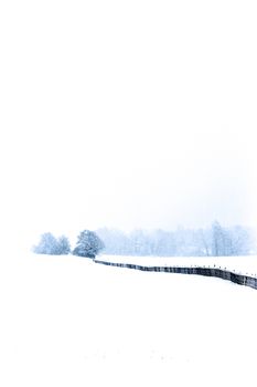Serene winter landscape in Lutry, Switzerland, showcasing snow-covered fields and trees.