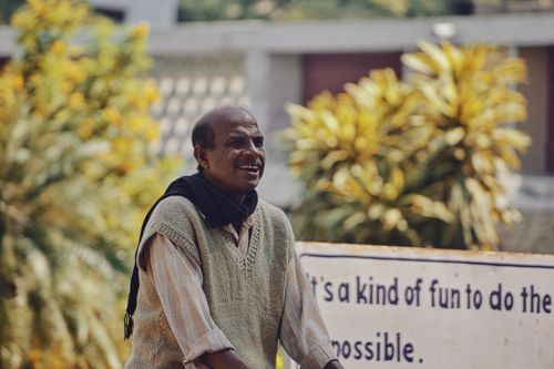 Free Cheerful man standing outdoors, conveying joy and positivity with an inspirational sign. Stock Photo