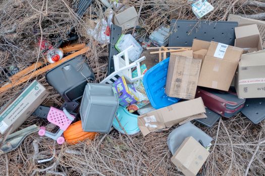 Aerial shot of mixed waste and discarded items including boxes, plastics, and branches outdoors.