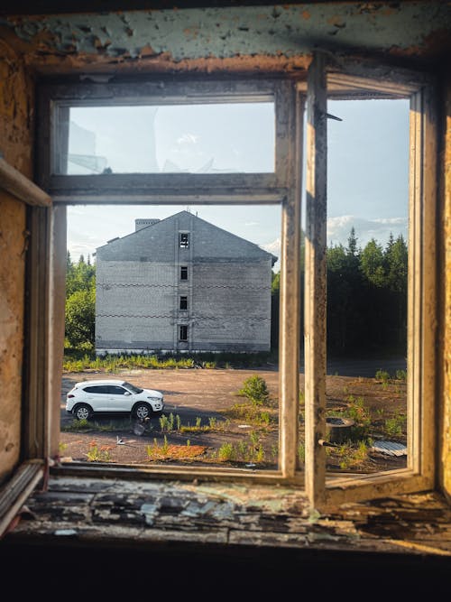 Car behind Destroyed Building Windows in Village