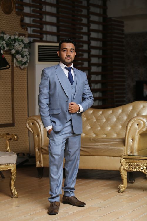 Free A man elegantly posing in a stylish blue suit, indoors in Karachi, Pakistan. Stock Photo