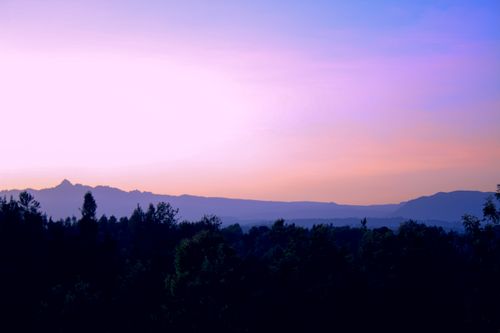 Free Scenic view of sunset over Mount Kenya in Meru County, Kenya. Vibrant colors and silhouette of trees create a captivating landscape. Stock Photo