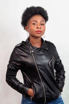Portrait of a young woman wearing a black leather jacket, embodying confidence and style in a studio setting.