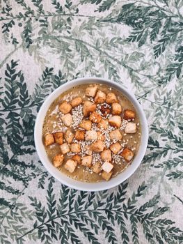 Delicious soup topped with crunchy croutons and sesame seeds in an artistic overhead shot.
