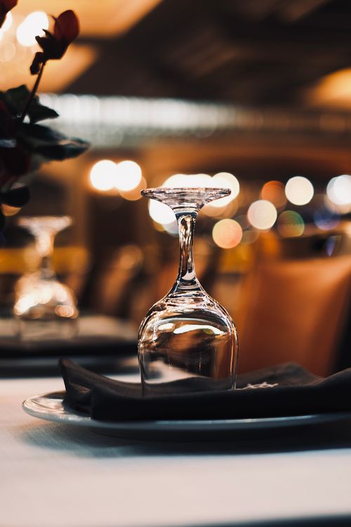 Free Close-up of an upside-down wineglass on a table with bokeh lights in the background. Stock Photo