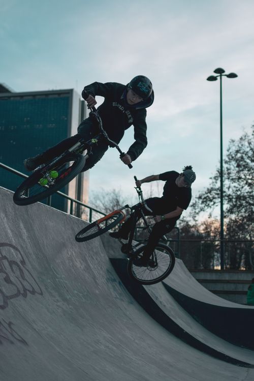 Free Two BMX riders execute dynamic stunts at a skate park in Ankara, capturing urban adventure. Stock Photo