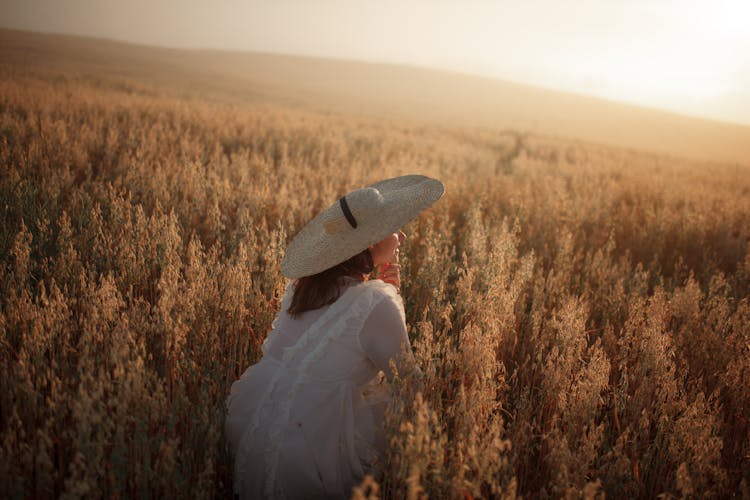 A Woman In A Field At Sunset