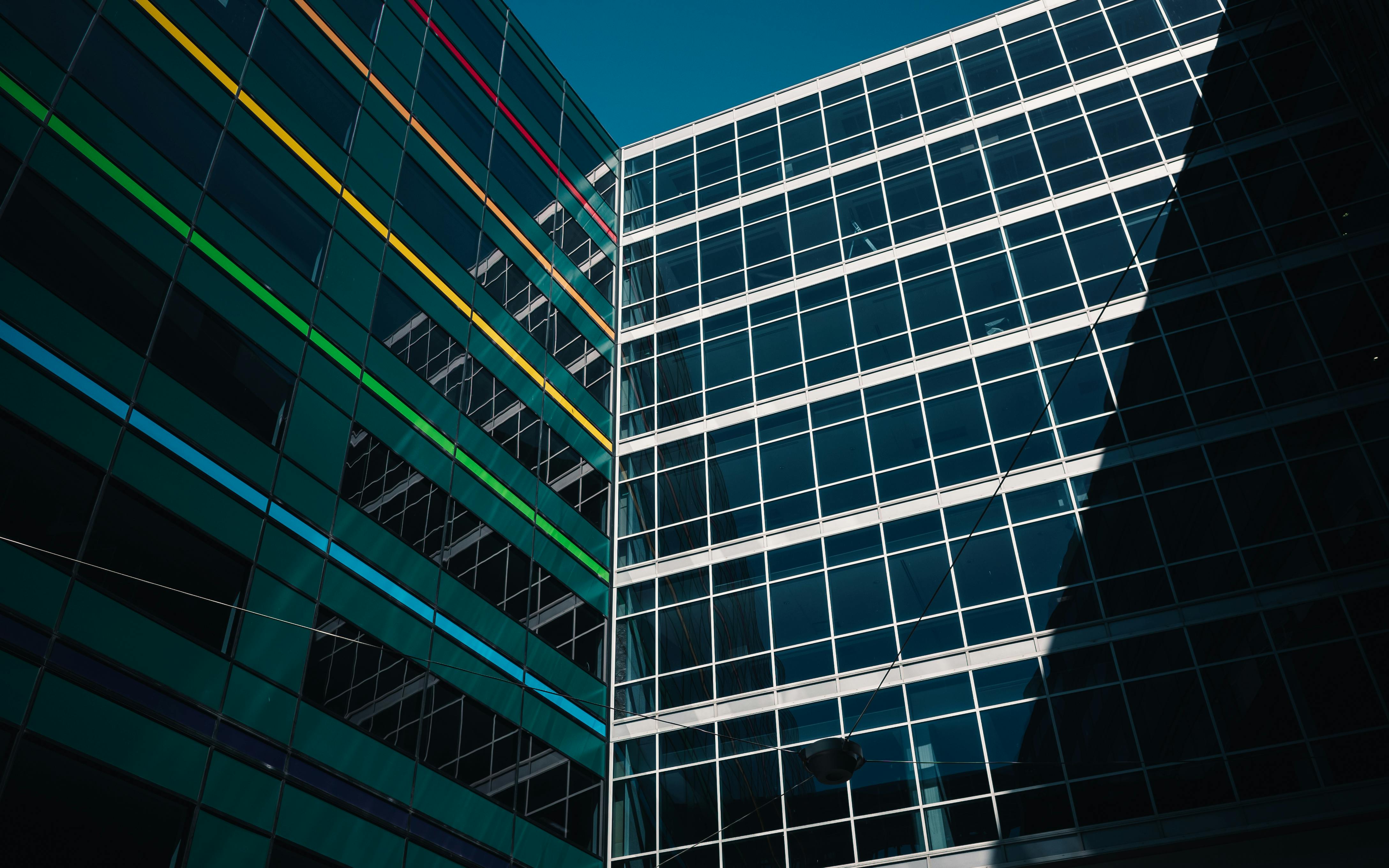 Architectural view of modern buildings with colorful stripes against a clear blue sky.