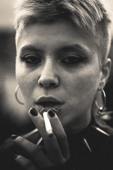 Artistic black and white portrait of a woman with a cigarette, conveying a moody atmosphere.