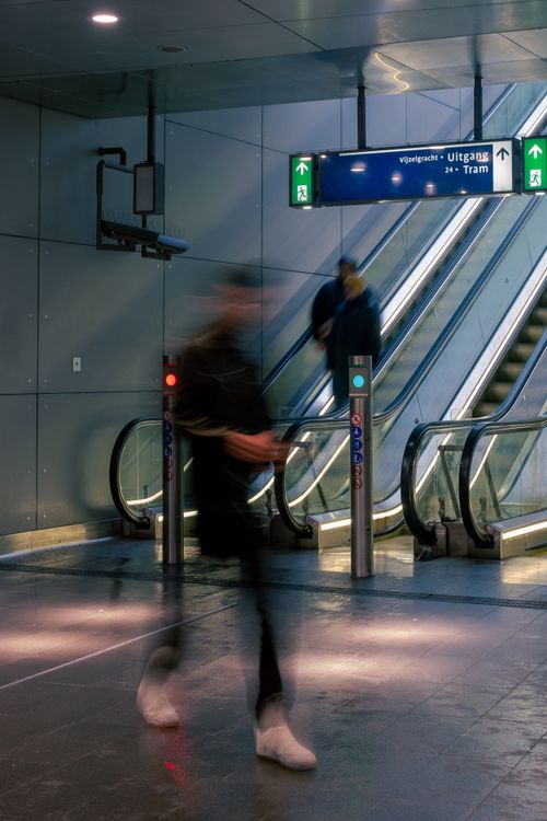 Free A dynamic scene in a subway station with blurred motion, escalators, and passengers. Stock Photo