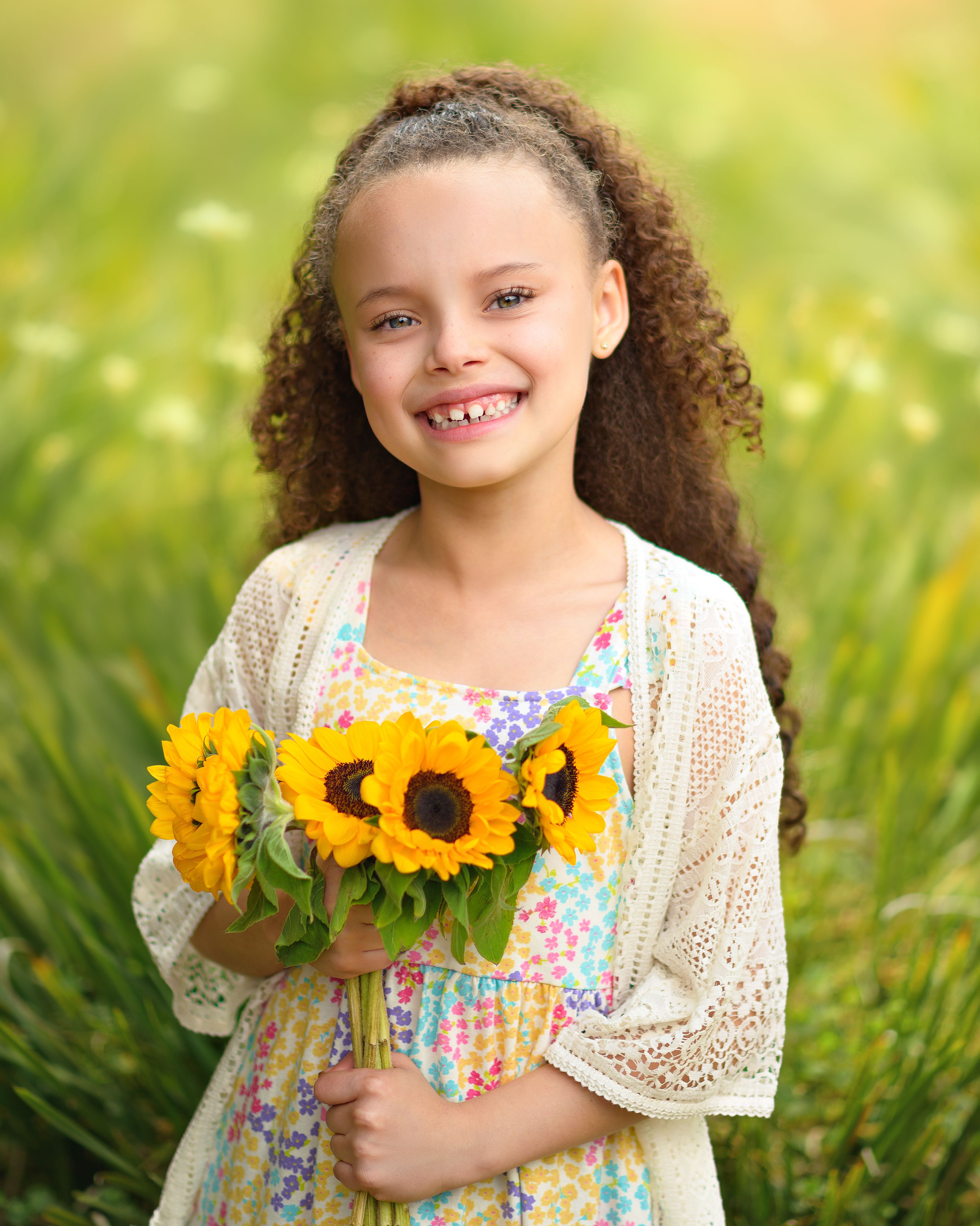 Cheerful young girl with sunflowers, capturing innocence and joy in a vibrant floral setting.