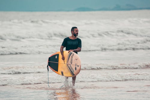 Photo of Man carrying a Surfboard