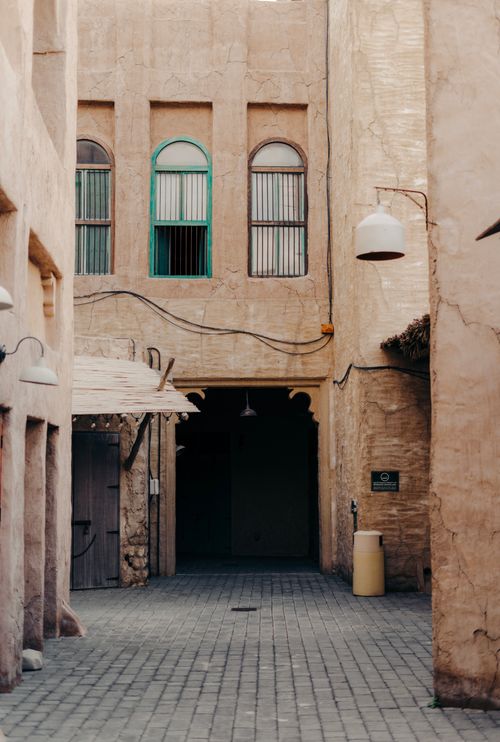 Free Explore a charming historic alley with rustic architecture and unique window designs. Stock Photo