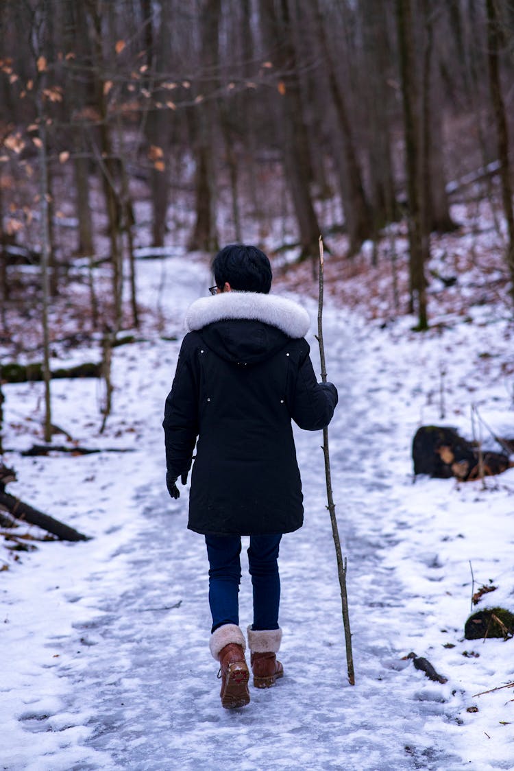 Person Holding A Stick While Walking