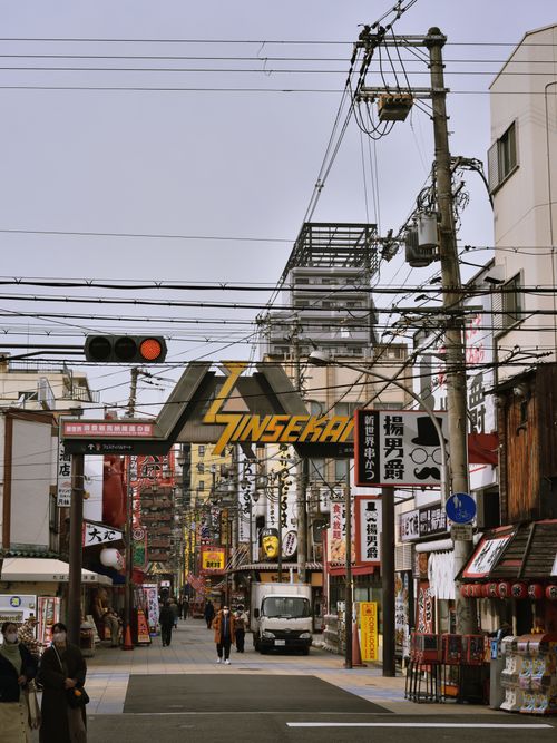 Free Explore the vibrant streetscape of Shinsekai in Osaka, featuring traditional architecture and bustling activity. Stock Photo