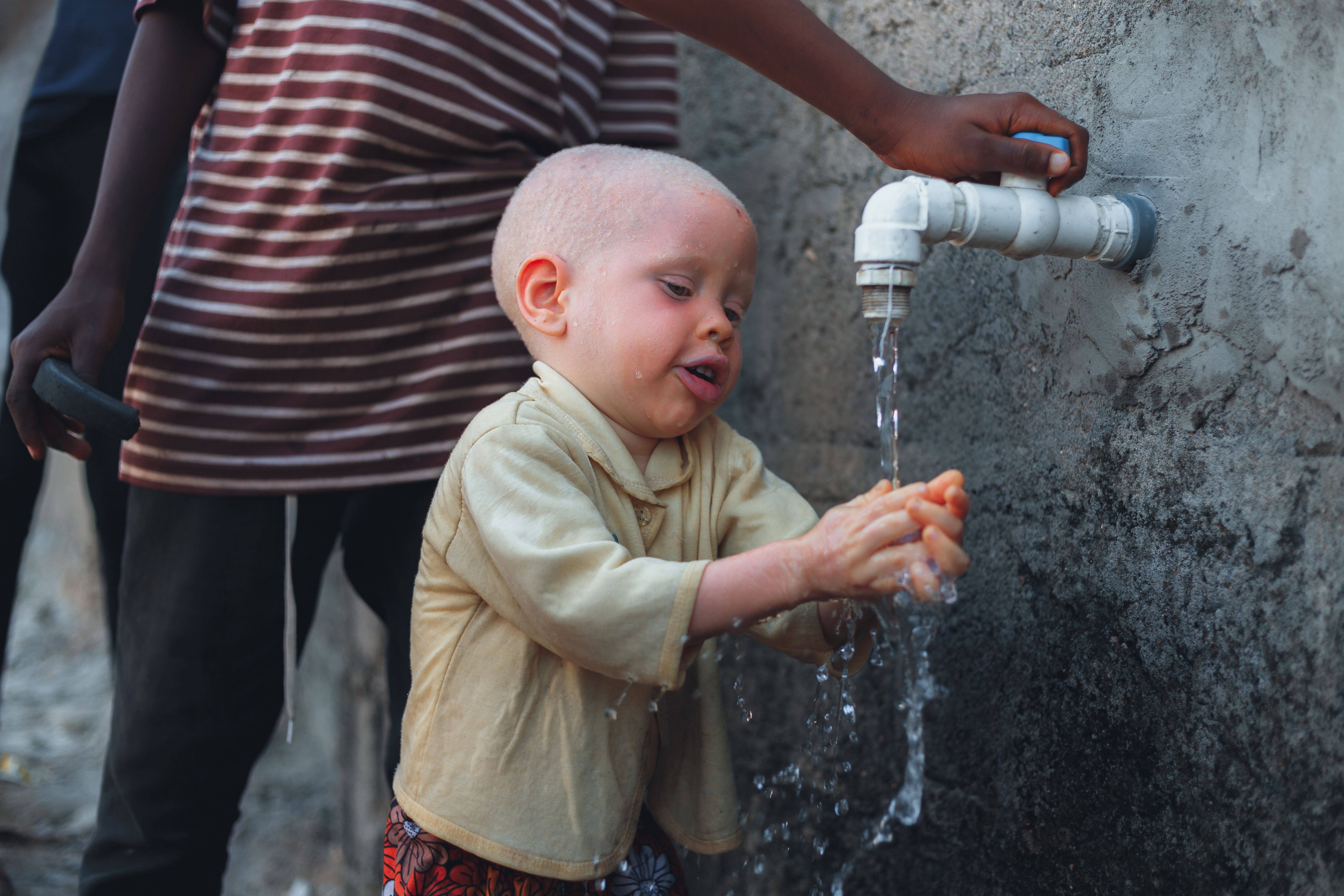 A child is drinking water from a tap · Free Stock Photo