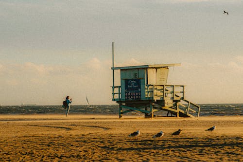 A Person Taking Photos of the Beach Near the Lifeguard Tower