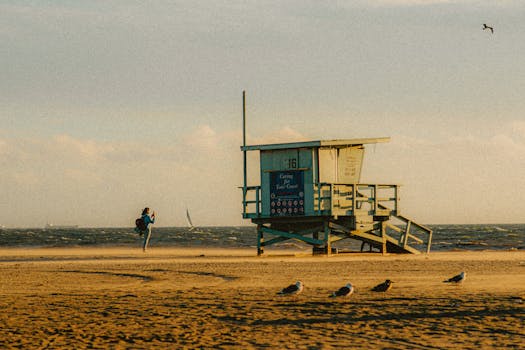 A serene evening scene with a lifeguard tower on a sandy beach, capturing the golden hour glow.