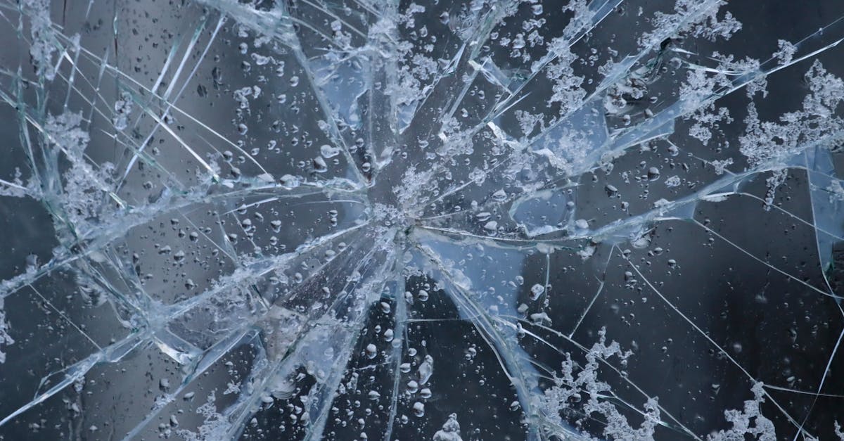 A close-up view of shattered glass with frost and water droplets, evoking winter in Sweden.