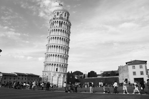 Free Black and white photo capturing the iconic Leaning Tower of Pisa in Italy, surrounded by tourists. Stock Photo