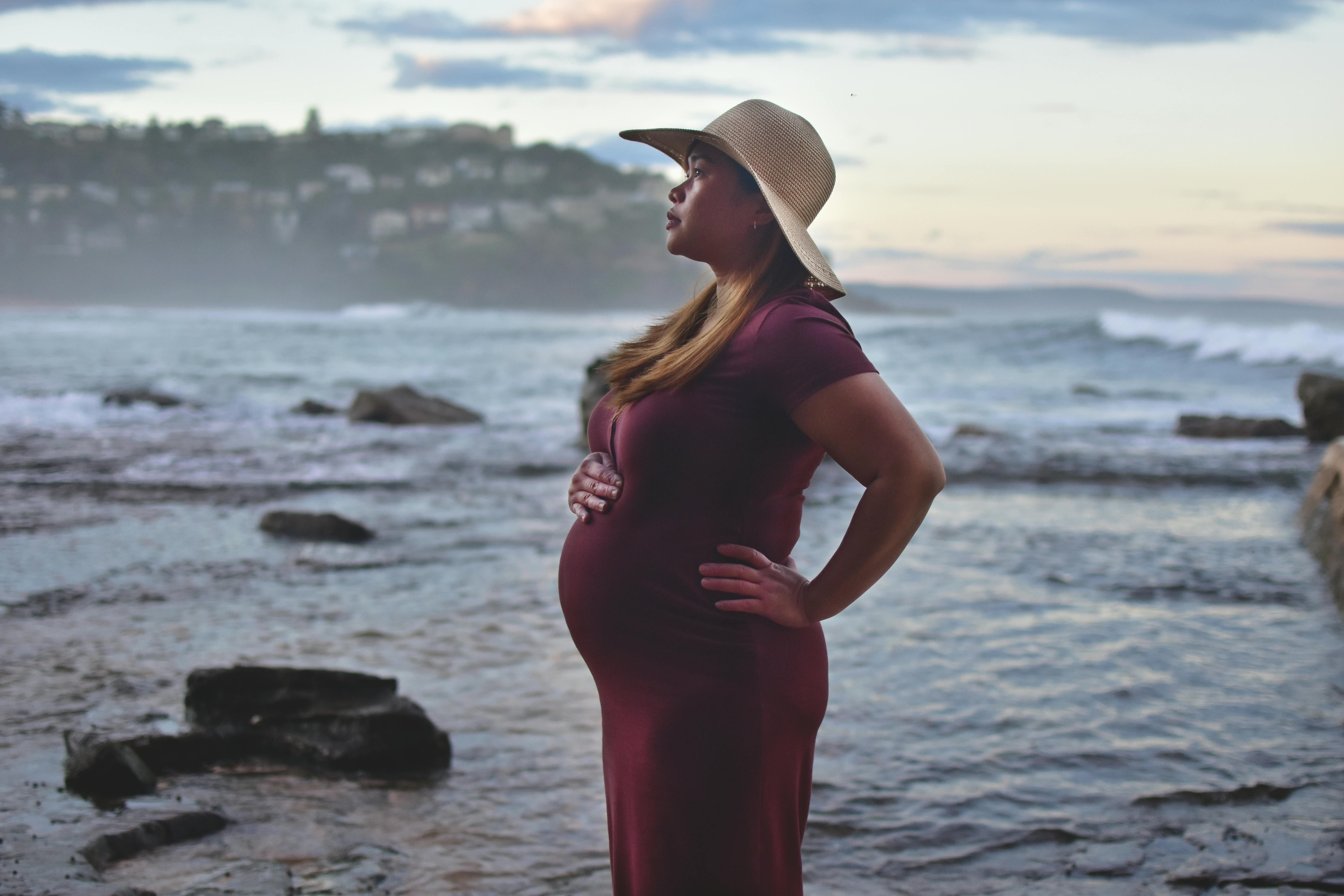 Pregnant Woman in Bikini Posing on Beach · Free Stock Photo