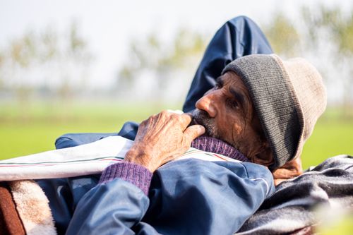 Free Close-up of a senior man wearing a beanie, relaxing outdoors during the day. Captures solitude and tranquility. Stock Photo