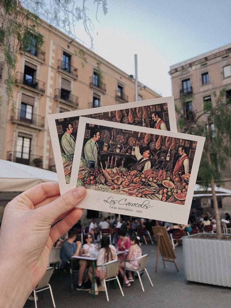 Person Holding Two Postcards