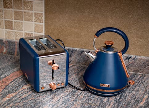 Stylish blue kettle and toaster set on a granite kitchen counter, adding a modern touch.