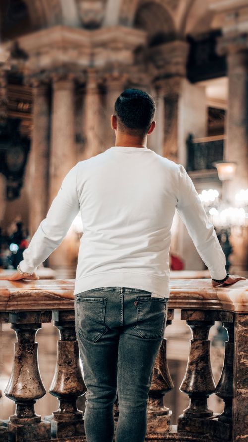Free Back view of a man in white shirt exploring historic architecture in Paris. Stock Photo