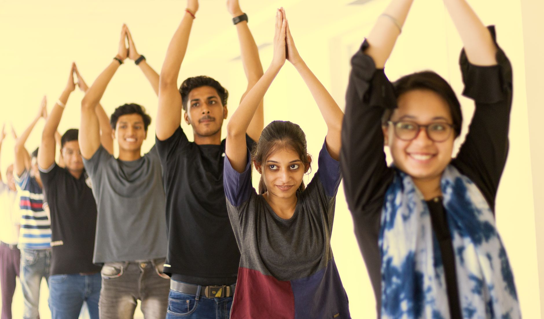 A vibrant group of young adults in a yoga class exuding enthusiasm and concentration.