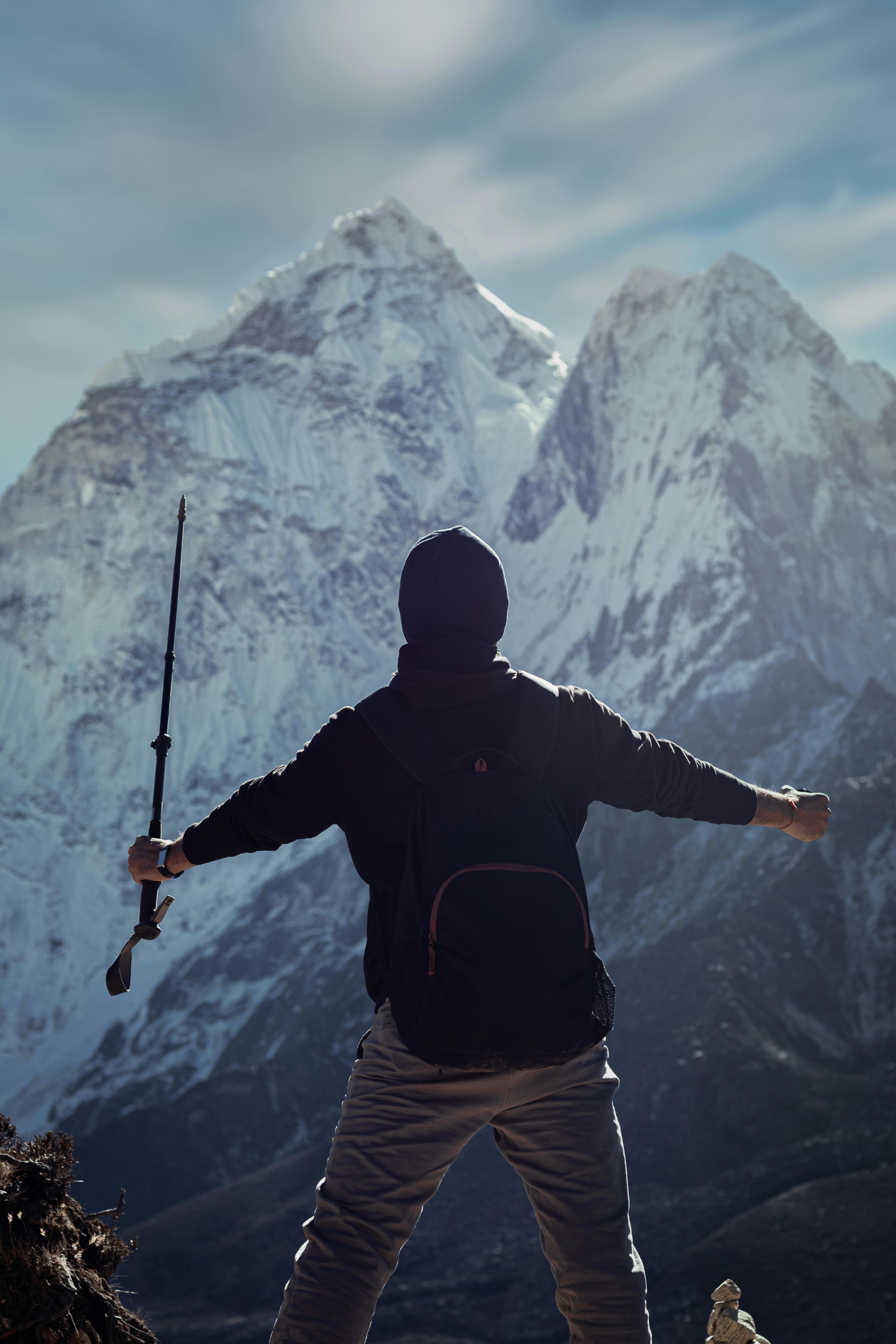 Prescription Goggle Inserts - Hiker celebrates atop snowy peaks in Dingboche, Nepal, embracing adventure and freedom.